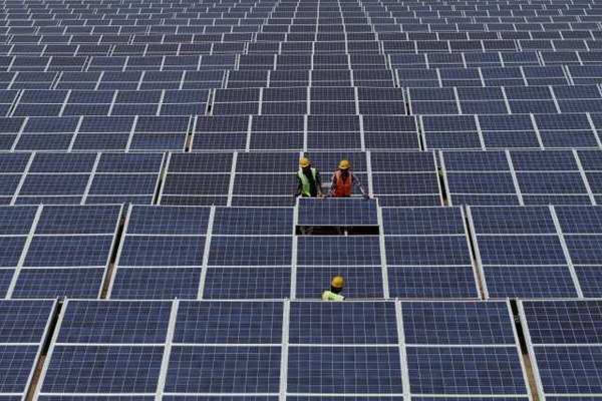 Indian workers install solar panels.