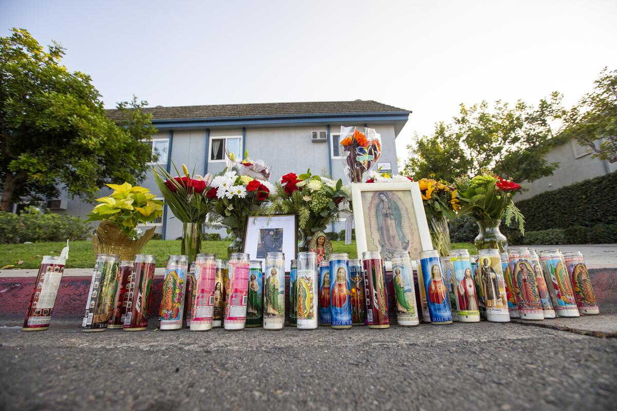 A sidewalk memorial for 30-year-old Lucas Rivera-Velasco included candles, flowers and a framed photograph. 