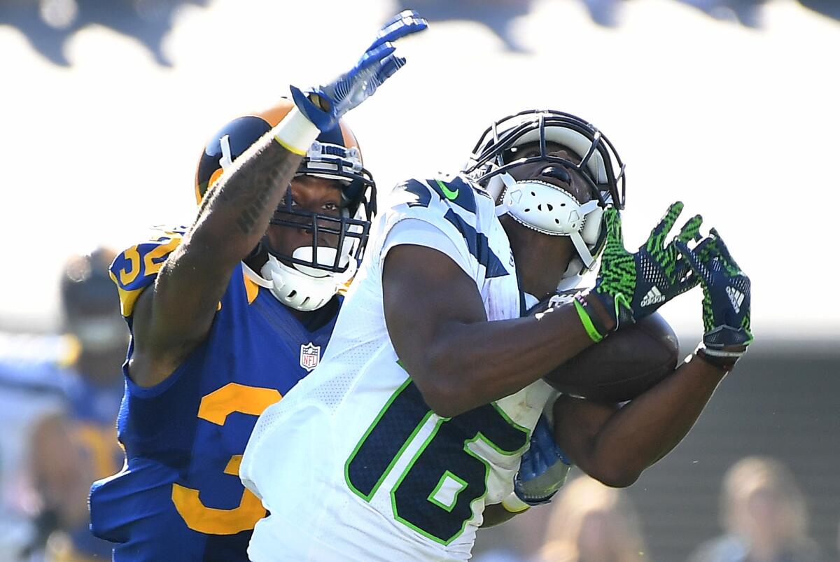 Rams' Troy Hill, left, can't stop Seattle's Tyler Lockett from hauling in a long pass on Sept. 18.
