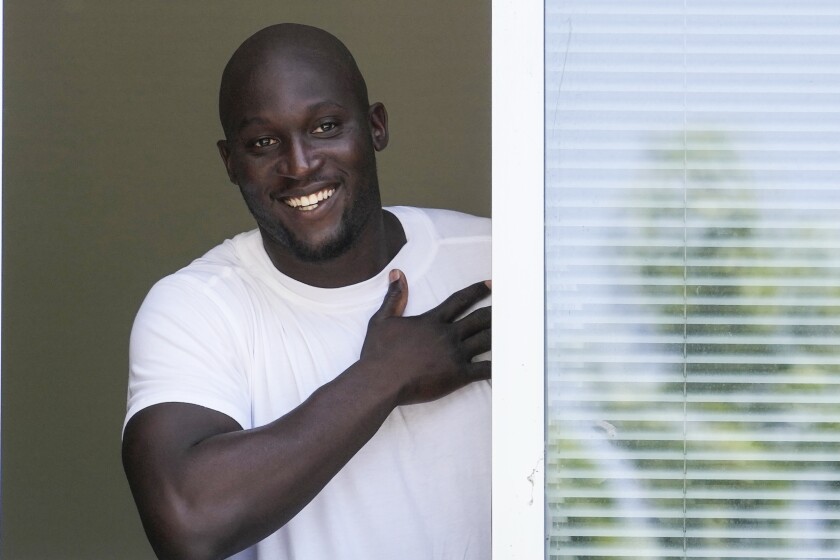 Soccer player Romelu Lukaku of Belgium cheers Inter Milan supporters from a window of the Italian Olympic Committee's headquarters in Milan, Italy, Wednesday, June 29, 2022. Lukaku is undergoing medical tests before transferring back to Inter from Chelsea. (AP Photo/Luca Bruno)