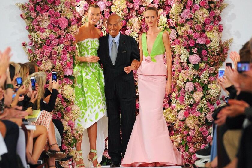 Designer Oscar de la Renta takes a bow with models Karlie Kloss, left, and Daria Strokous after his spring 2015 collection is modeled during Fashion Week in New York.