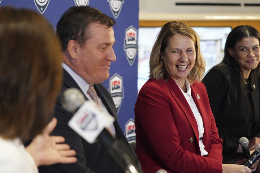 Minnesota Lynx head coach Cheryl Reeve, flanked by USA Basketball CEO Jim Tooley and Women's National Team Director Briana Weiss, smiles as Bally Sports North announcer Marney Gellner jokingly asked if there was going to be an official Coach Reeve blazer during a press conference to announce she'd been named the head coach of women's USA Basketball, Wednesday, Dec. 8, 2021, at the Target Center in Minneapolis. (Anthony Souffle/Star Tribune via AP)