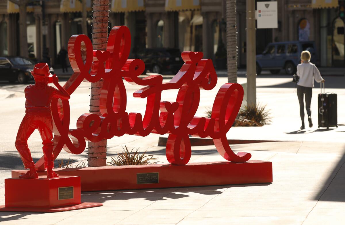 A pedestrian walks by a "Life is Beautiful" sculpture in Beverly Hills on Oct. 27.