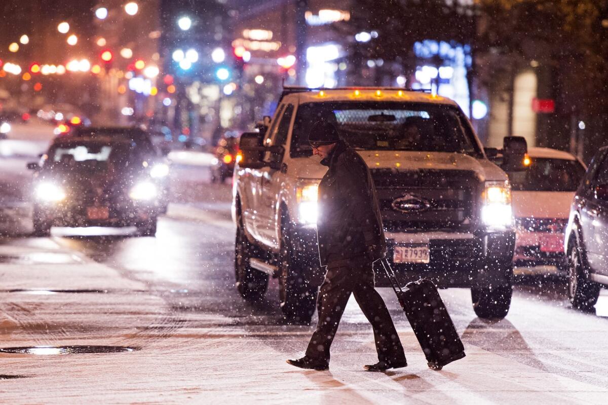 A man crosses a snow-covered road in downtown Washington.