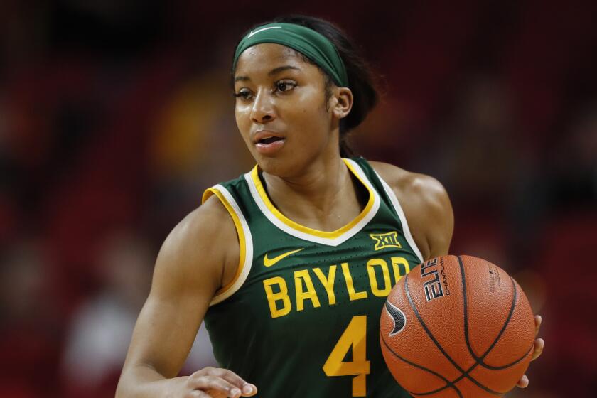 Baylor guard Te'a Cooper drives up court during an NCAA college basketball game.