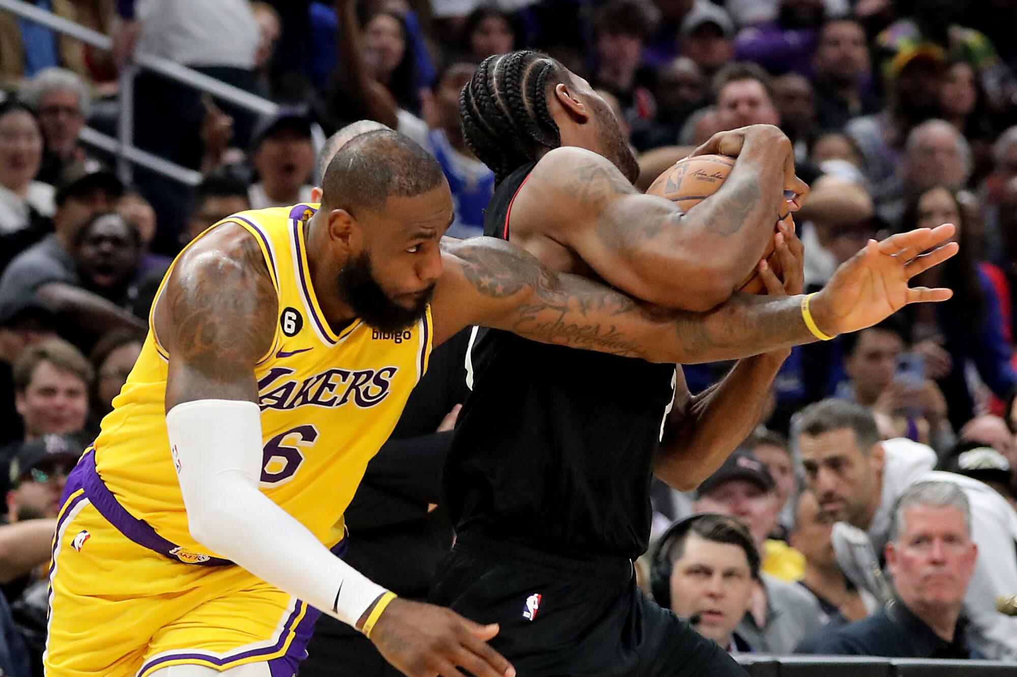 Lakers forward LeBron James, left, gets tangled with Clippers forward Kawhi Leonard as they battle for a loose ball.