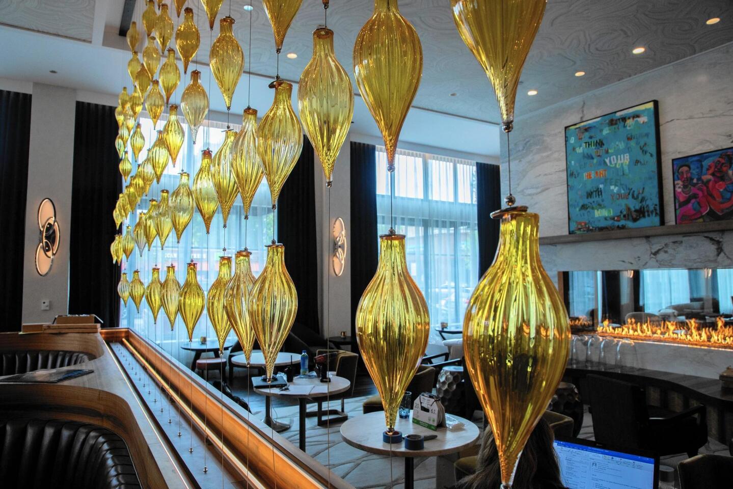 Amber-colored glass beads provide a translucent transition between the music-inspired lobby and the more scientific-minded bar.