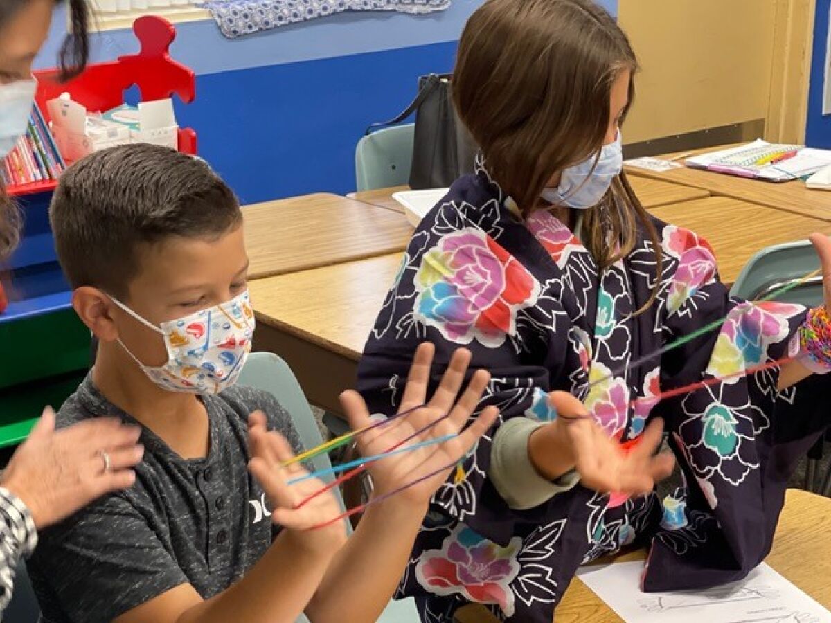 Third graders, Hudson Bass and Ariana Animpour learn about Japanese culture by taking part in a hands-on session.