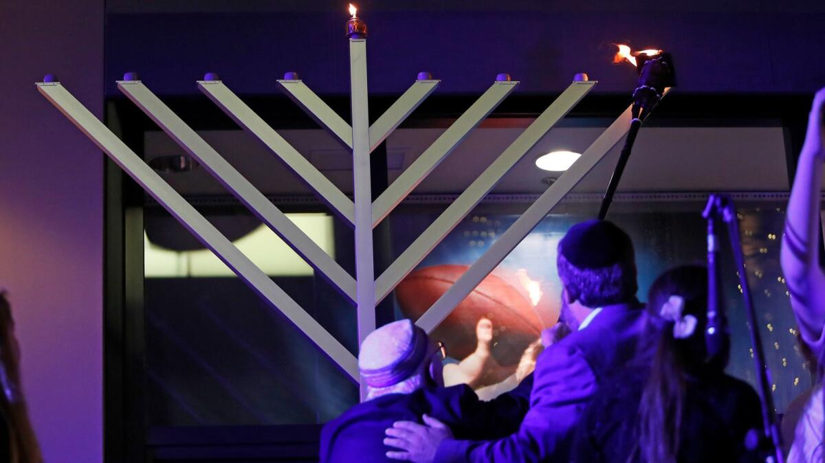 Dr. Jacob Eisenbach, left, and Rabbi Mintz light the menorah at Fashion Island on Tuesday.