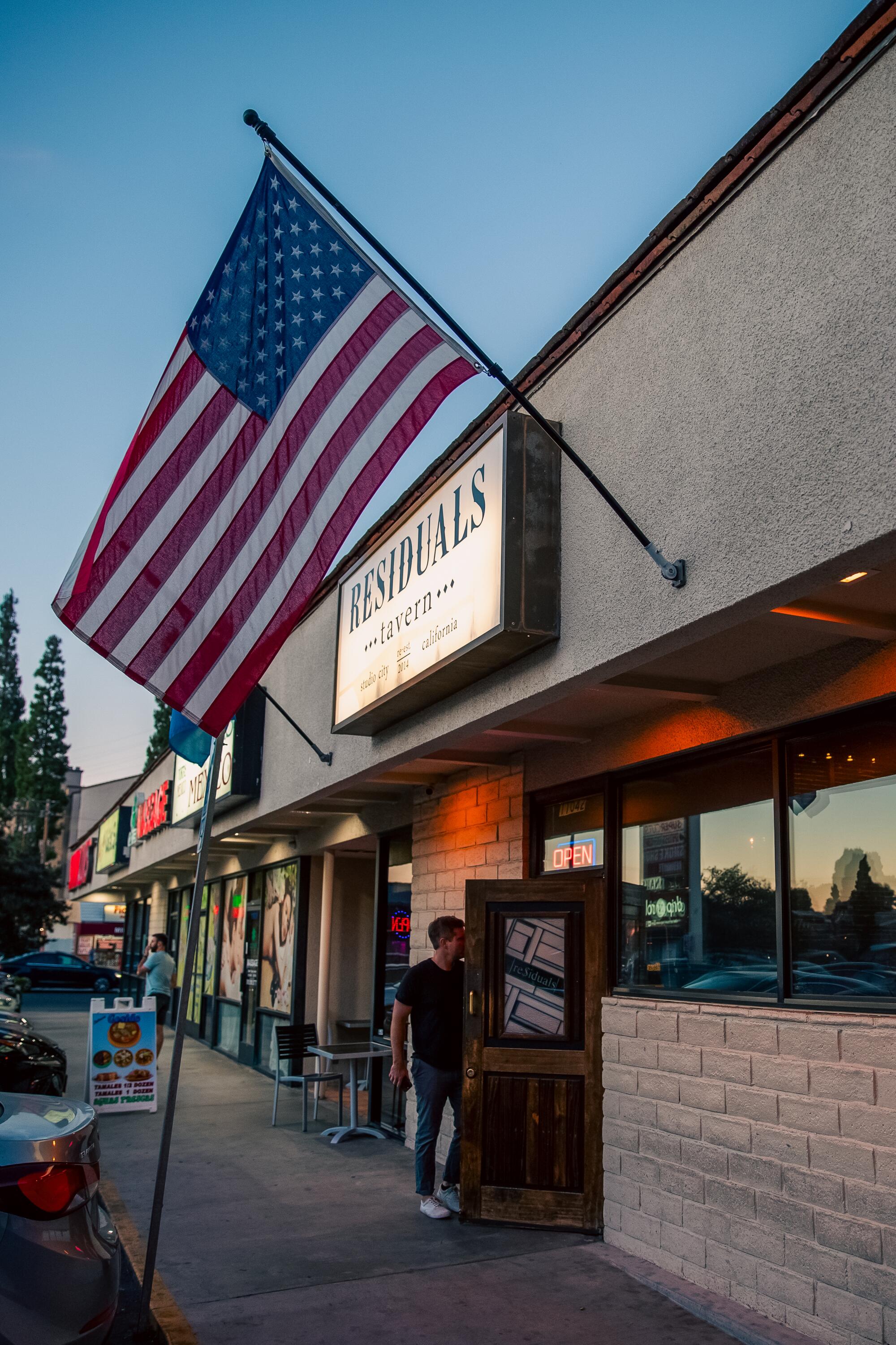 An exterior of a bar with an American flag.