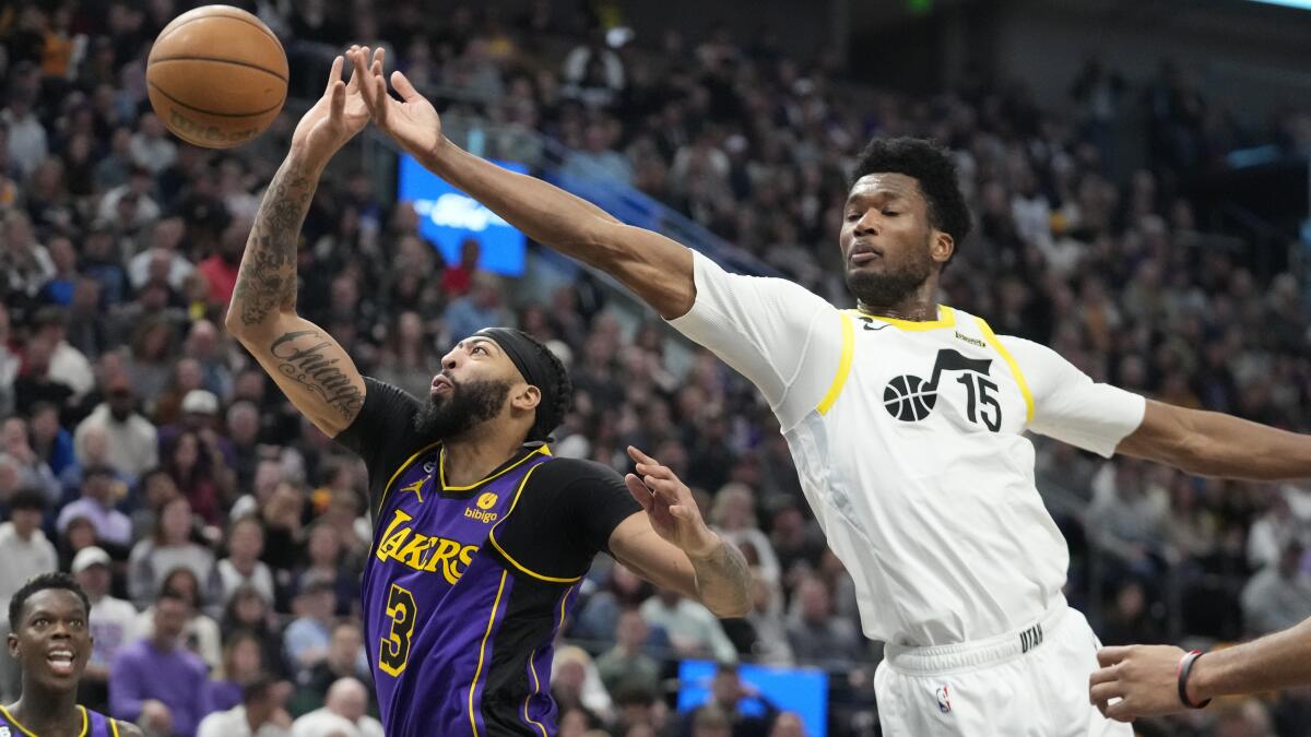 Lakers forward Anthony Davis and Utah Jazz center Damian Jones reach for a rebound.