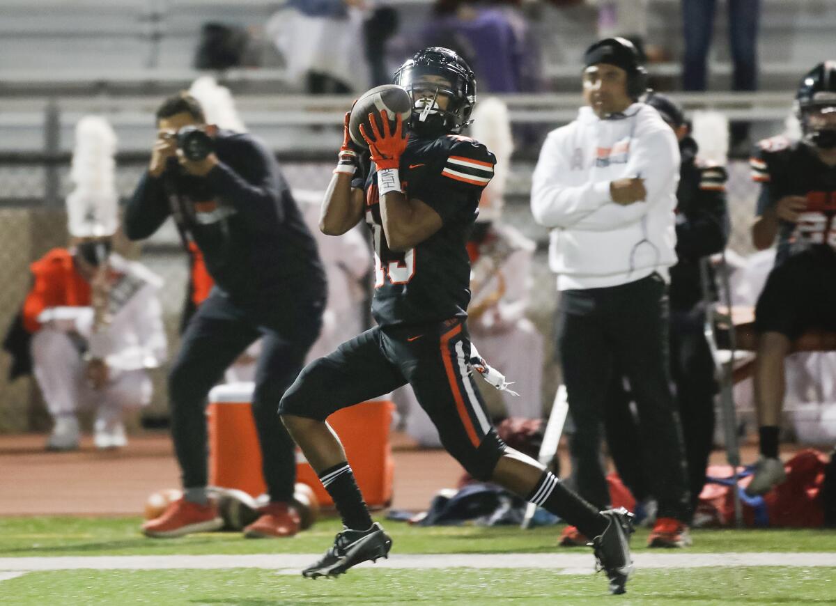Huntington Beach receiver Jordan Castro makes a catch at the sideline and sprints for a touchdown against Marina.