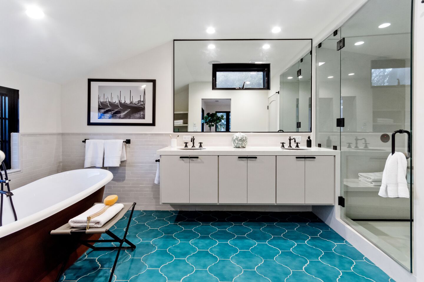 A freestanding tub and bright tile accent a bathroom.