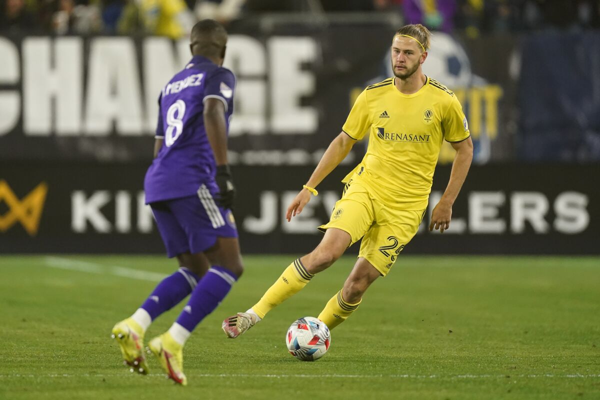 Nashville SC defender Walker Zimmerman dribbles against Orlando City midfielder Sebastian Mendez
