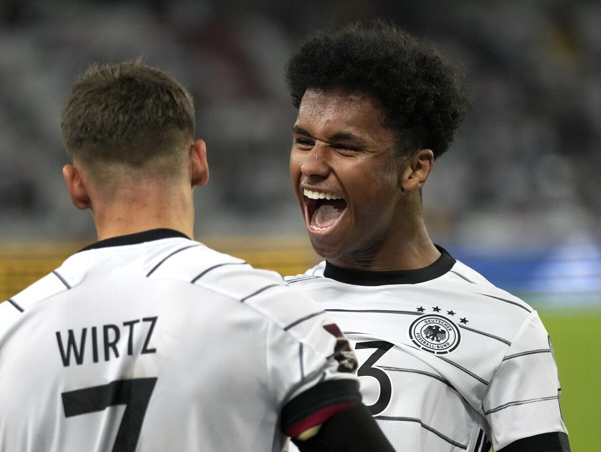 Germany's scorer Karim Adeyemi, right, and his teammate Florian Wirtz celebrate their side's sixth goal during the World Cup 2022 group J qualifying soccer match between Germany and Armenia at Mercedes-Benz Arena stadium in Stuttgart, Germany, Sunday, Sept. 5, 2021. (AP Photo/Matthias Schrader)