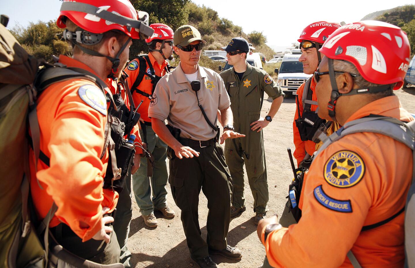 Ventura County Sheriff's Deputy Chris Johnston, center, holds a pre-flight briefing with members of Ventura County Sheriff's Search and Rescue team as they prepare to board a helicopter to search for Mike Herdman, the Arcadia firefighter who went missing June 13.