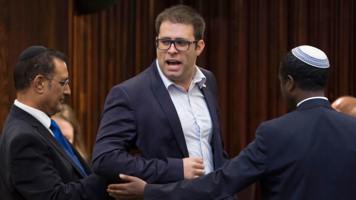 A 2015 photo shows Oren Hazan, a Likud Party parliament member, being escorted out of the parliament hall by ushers.