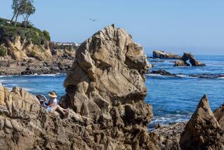 Newport Beach, CA - March 19: Beach-goers enjoy the view from the rocks on the first day of spring with clear skies and warm weather at Little Corona del Mar Beach in Newport Beach Tuesday, March 19, 2024. (Allen J. Schaben / Los Angeles Times)