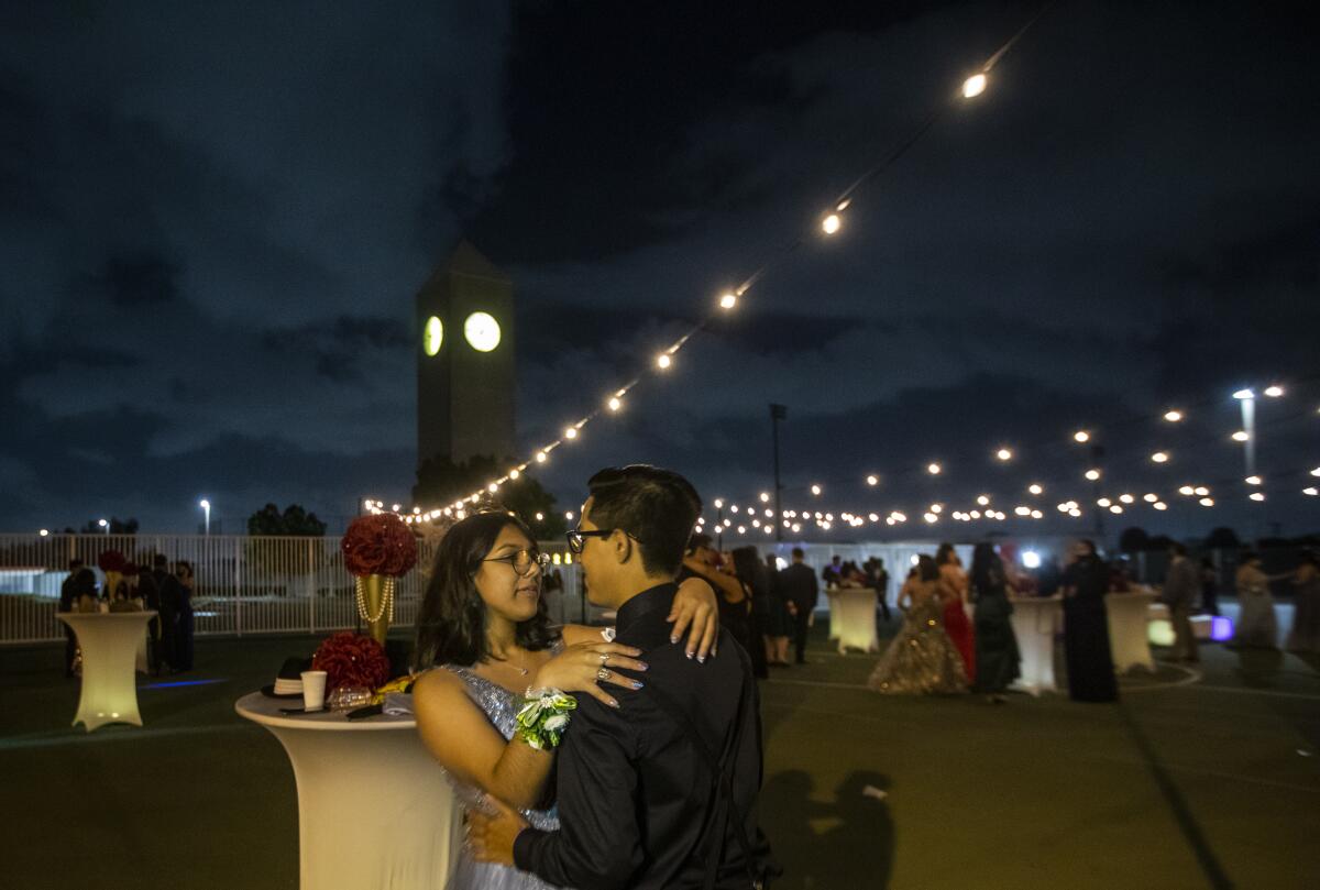 A couple dancing outdoors at a prom. 