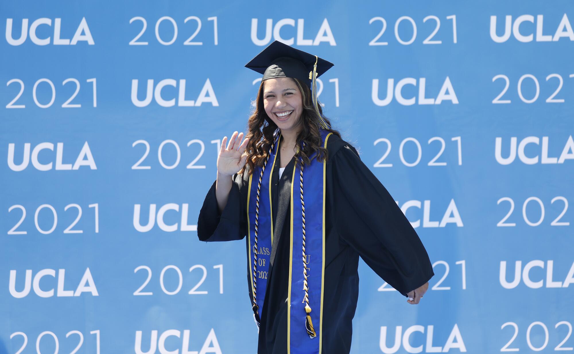 Graduating with a degree in biology and Chicana/o Studies, Jennifer Bribiesca waves to her family.