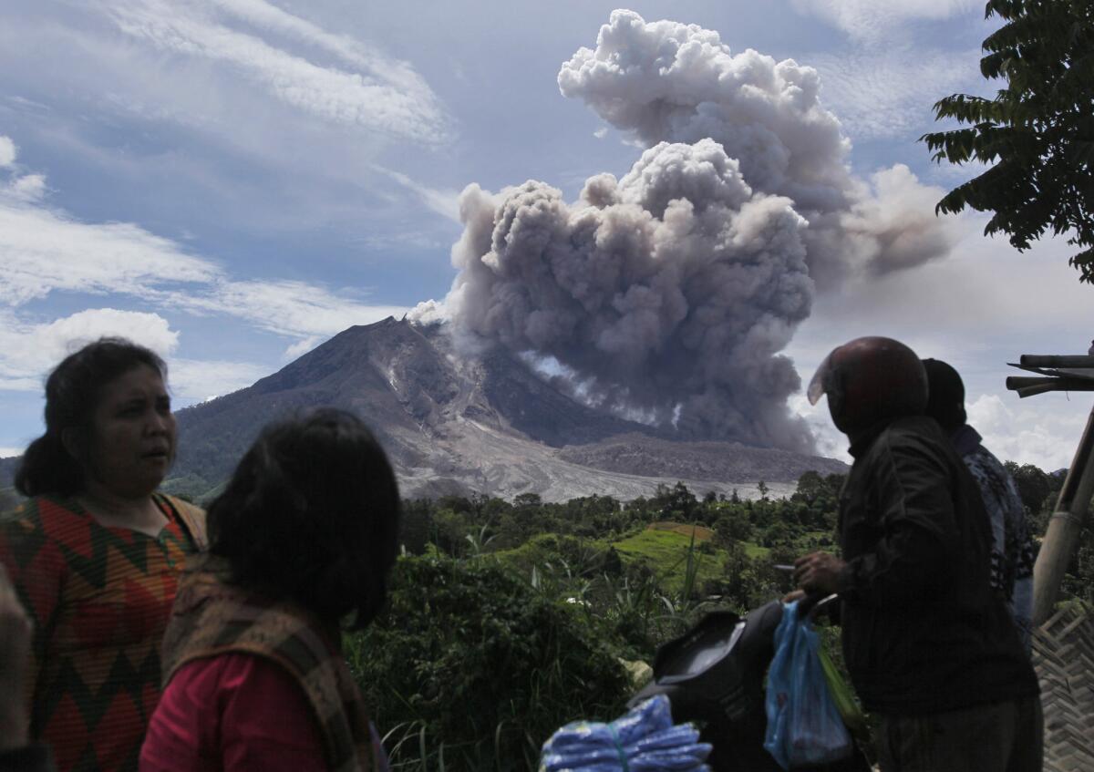 Villagers watch as Mount Sinabung erupts in Tiga Pancur, North Sumatra, Indonesia.