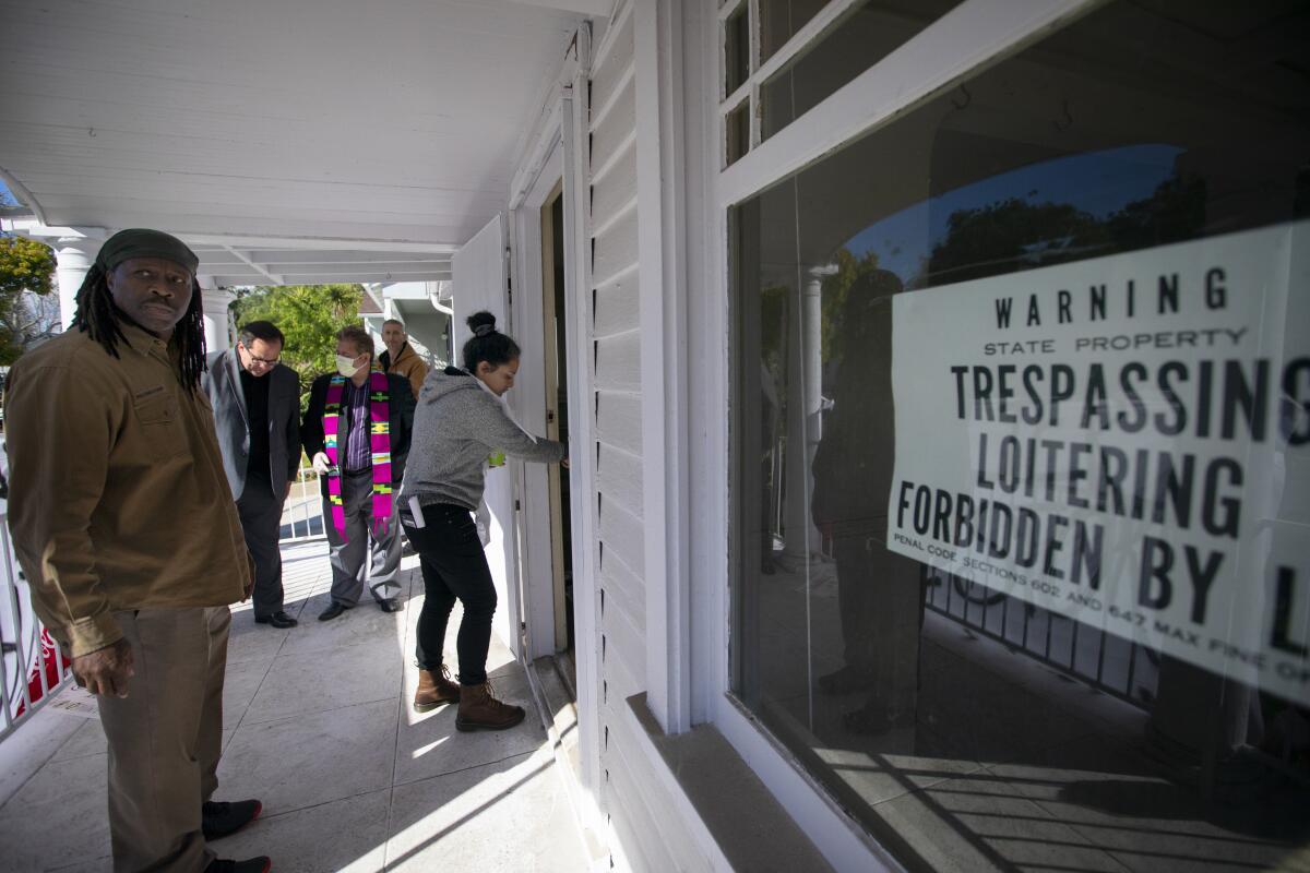 People enter a house with a "no trespassing" sign