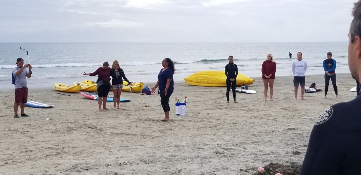 Kuuipo Kekawa leads paddle-out participants in a "calling in of the ancestors" chant and blessing at La Jolla Shores.