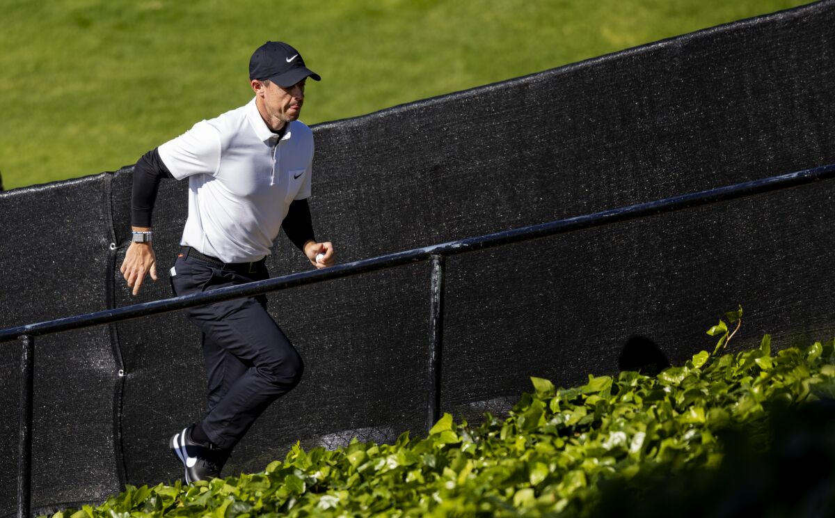 Rory McIlroy runs up the stairs after finishing the ninth hole during the second round of the Genesis Invitational.