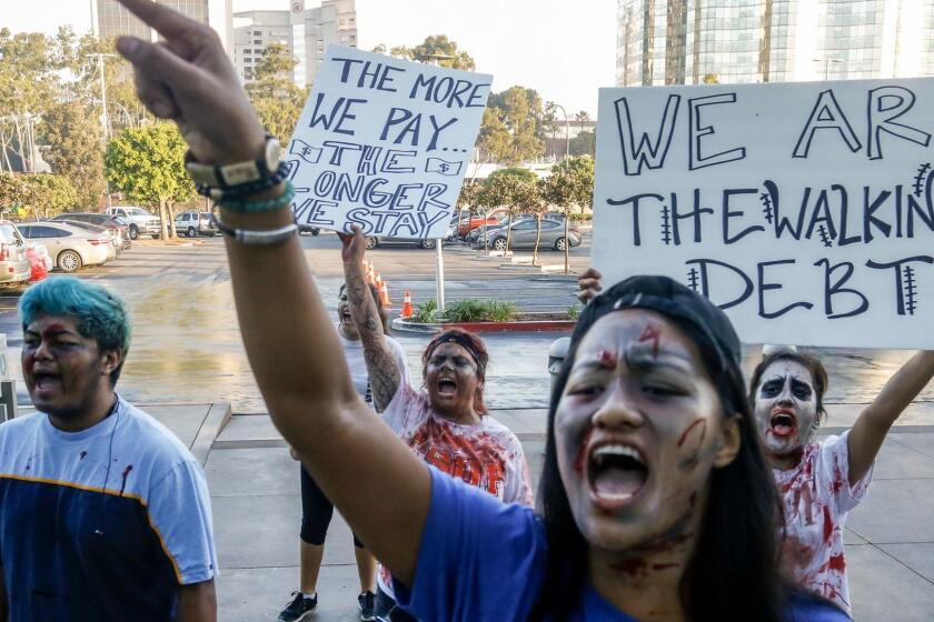LONG BEACH, CA., NOVEMBER 15, 2016: Cal State University Fullerton student Ginny Dolores leads Several dozen other Cal State students protesting the possible tuition hike in front of the Cal State University Chancellor's office in Long Beach November 15, 2016. With face paint and fake blood, the peaceful student demonstration dubbed," The Walking Debt" dramatized the plight of students, should a tuition hike take place (Mark Boster/ Los Angeles Times).