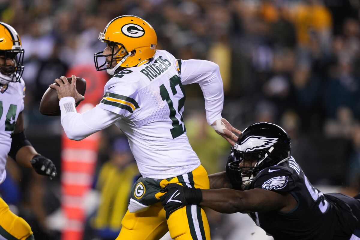 Green Bay Packers quarterback Aaron Rodgers (12) is pressured by Philadelphia Eagles' Javon Hargave during the first half of an NFL football game, Sunday, Nov. 27, 2022, in Philadelphia. (AP Photo/Matt Slocum)