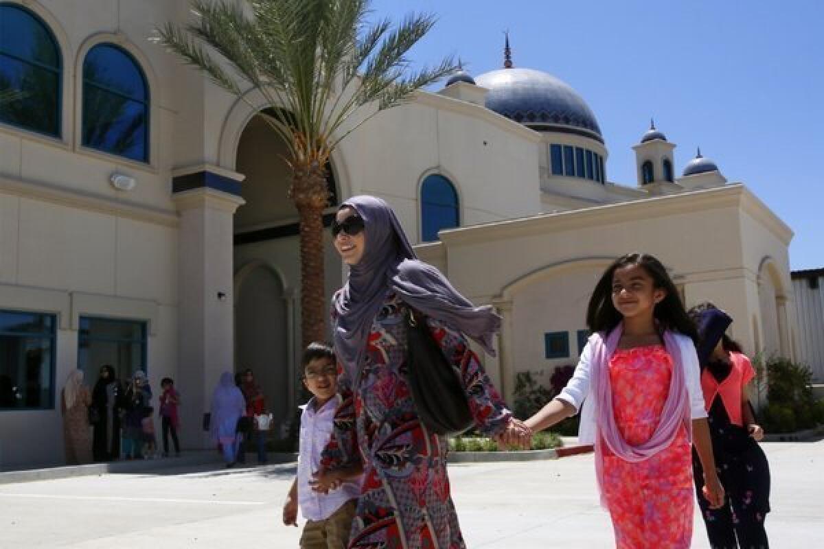 Anushe Khan, 27, with her children Yousuf, 5, left, Ayesha, 9, and Asma, 7, comes out of the newly constructed Islamic Center of San Gabriel Valley after attending first Friday prayers in Rowland Heights.