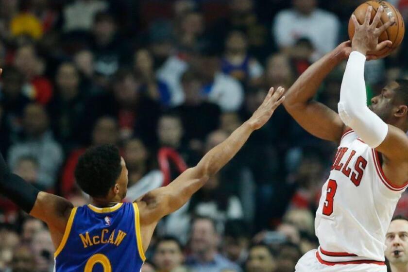 Bulls guard Dwyane Wade (3) shoots over Golden State Warriors guard Patrick McCaw during the first half on Mar. 2 in Chicago.