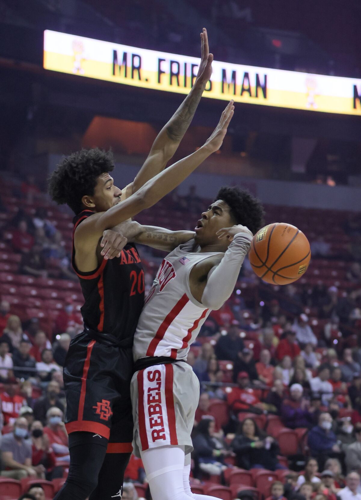 Keshon Gilbert of UNLV loses the ball as he drives to the basket against Chad Baker-Mazara of San Diego State.