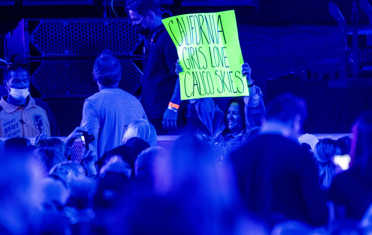 A woman holds a sign before Paul McCartney takes the stage.