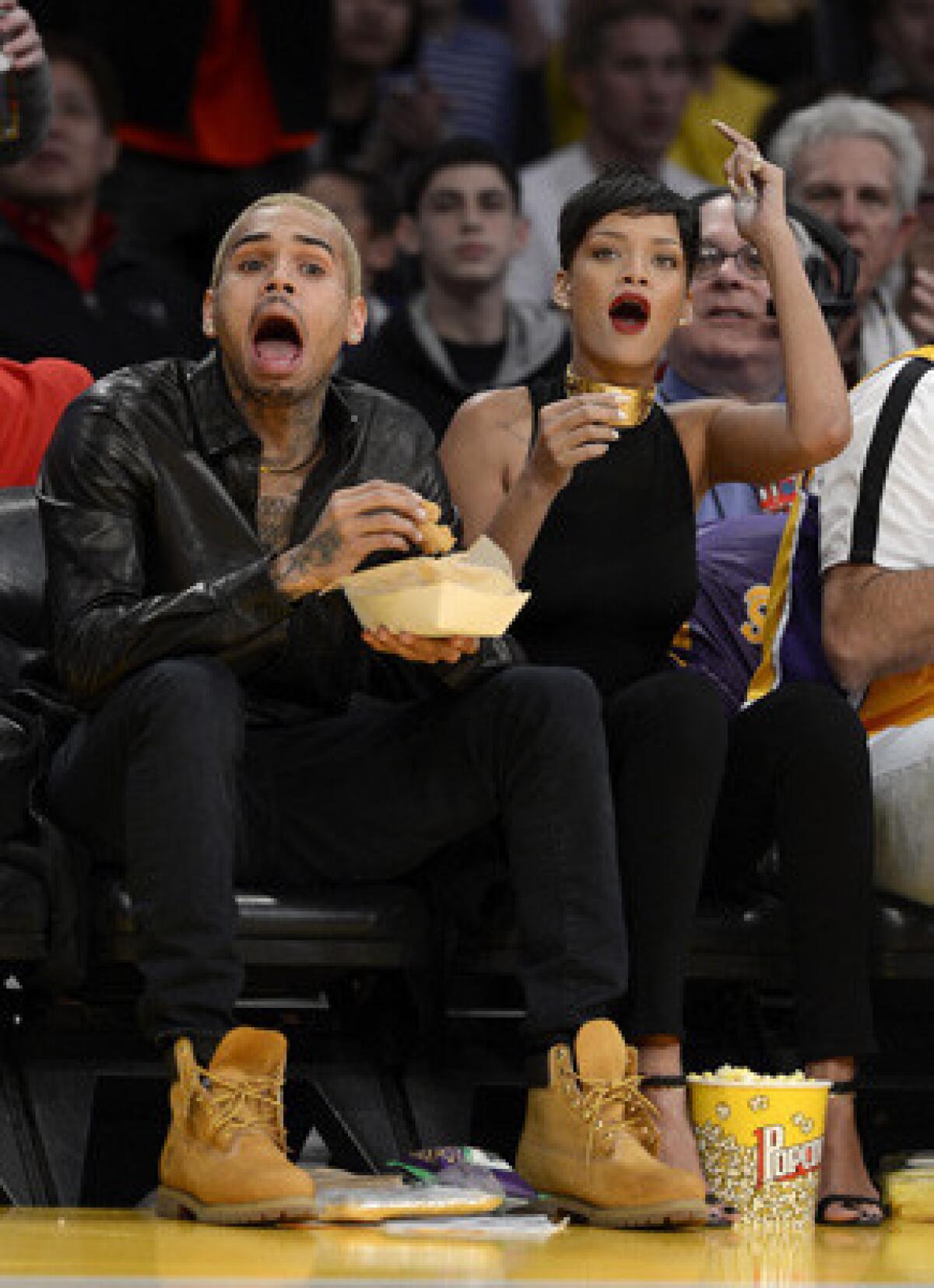 Rihanna, with Chris Brown at a Los Angeles Lakers game in December, says she's "happy" to be back with Brown.