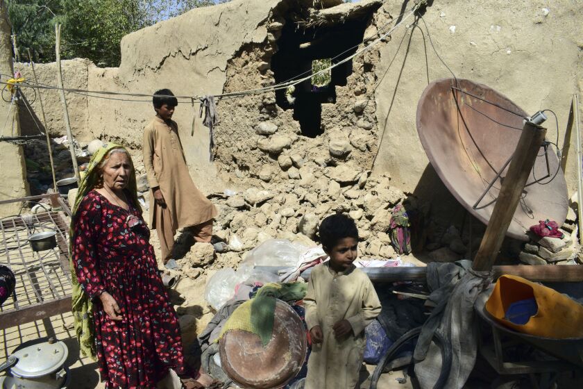 A family is seen inside their house following an earthquake in Harnai, about 100 kilometers (60 miles) east of Quetta, Pakistan, Thursday, Oct. 7, 2021. The powerful earthquake collapsed at least one coal mine and dozens of mud houses in southwest Pakistan early Thursday. (AP Photo/Arshad Butt)