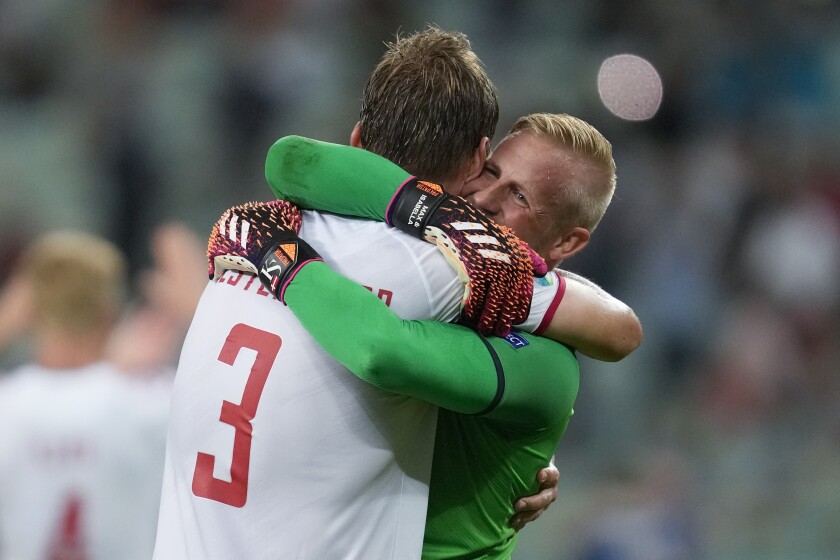Denmark's goalkeeper Kasper Schmeichel, right, hugs Jannik Vestergaard at the end of the Euro 2020 soccer championship quarterfinal match between Czech Republic and Denmark, at the Olympic stadium in Baku, Saturday, July 3, 2021. Denmark won 2-1 and advances to the semifinals. (AP Photo/Darko Vojinovic, Pool)