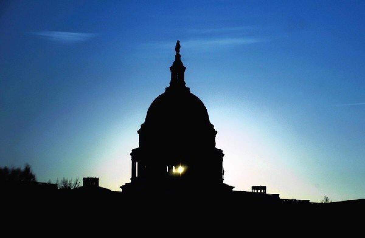 The Capitol dome in Washington silhouetted against a low sun