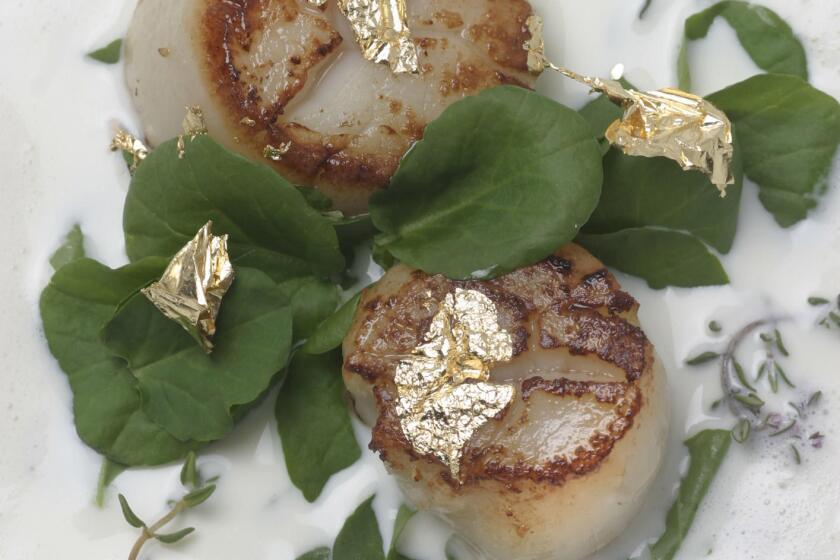 Young garlic soup with thyme, scallops and gold leaf.