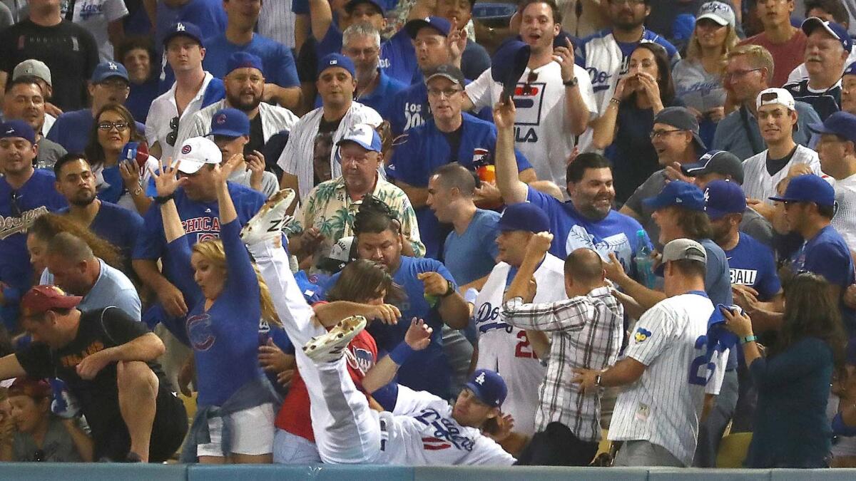 Dodgers right fielder Josh Reddick dives into the right field seats but misses a foul ball hit by Cubs Ben Zobrist,