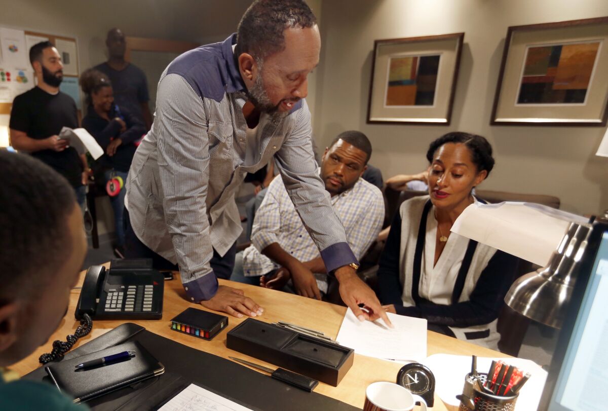 Executive producer of "black-ish" Kenya Barris, left, talks with Anthony Anderson and Tracee Ellis Ross on the set during rehearsal
