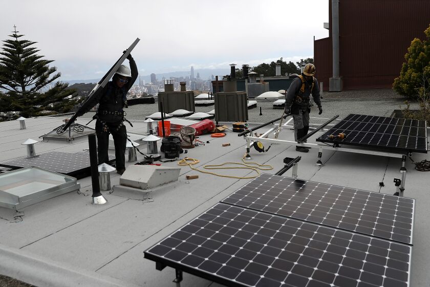 SAN FRANCISCO, CA - MAY 09: Luminalt solar installers Pam Quan (L) and Walter Morales (R) install solar panels on the roof of a home on May 9, 2018 in San Francisco, California. The California Energy Commission is set to vote on proposed legislation that would require all new homes in the state of California to have solor panels. If passed, the new mandate would require the panels on new homes up to three stories tall and is estimated to cost nearly $10K per home. (Photo by Justin Sullivan/Getty Images)
