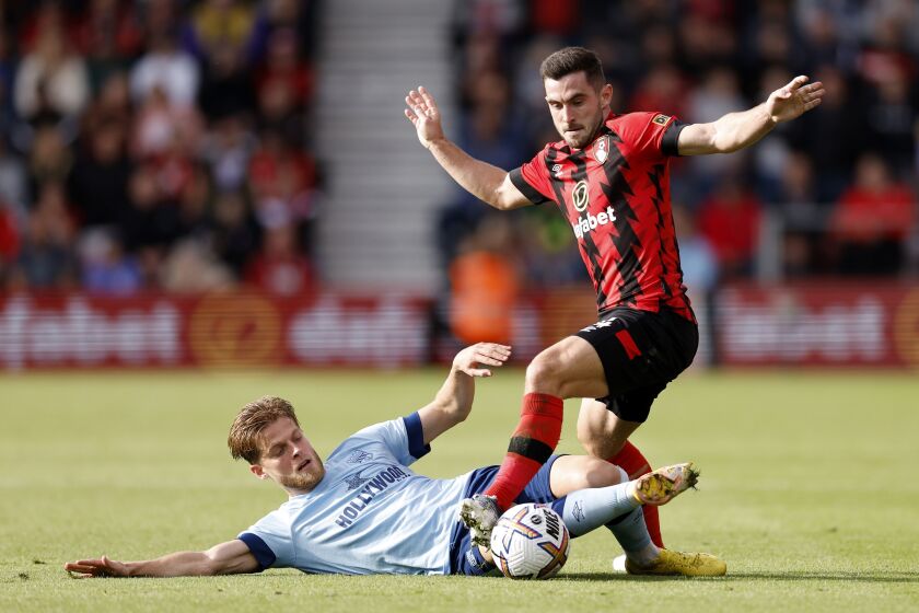 Brentford's Mathias Jensen, left, and Bournemouth's Lewis Cook battle for the ball during their English Premier League soccer match at the Vitality Stadium, Bournemouth, England, Saturday, Oct. 1, 2022. (Steven Paston/PA via AP)