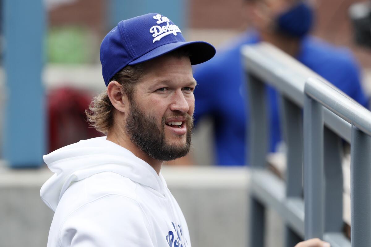 Los Angeles Dodgers' Clayton Kershaw stands in the dugout wearing a new Los Dodgers uniform 