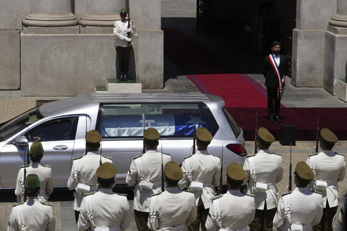 El presidente chileno Gabriel Boric observa el coche fúnebre 