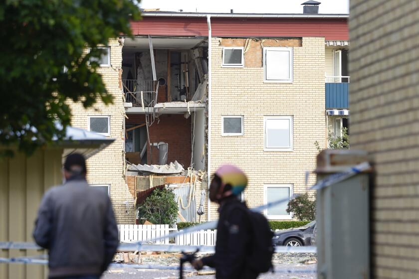 People look at the damages caused by an explosion in a residential building in the Ekholmen area, in Linköping, Sweden, Tuesday, Sept. 26, 2023. (Stefan Jerrevång/TT News Agency via AP)