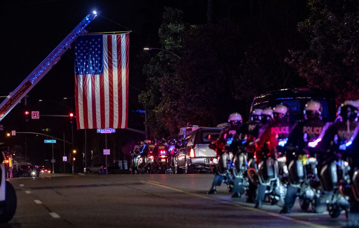 A giant American flag was hoisted from a fire truck, and motorcycle police paraded around the hearse.