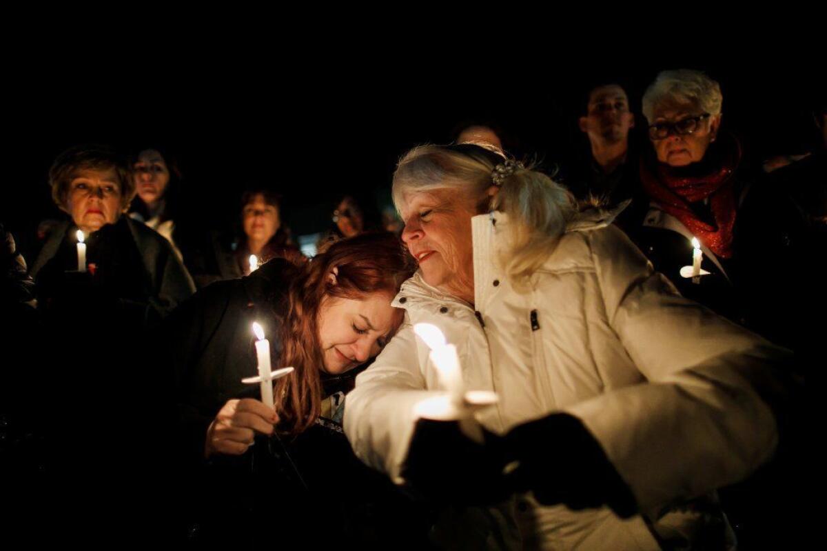 Jeannie Durbin-Hambric, left, leans on Linda Grise, as they join other community members for a vigil at Glenknoll Elementary School.