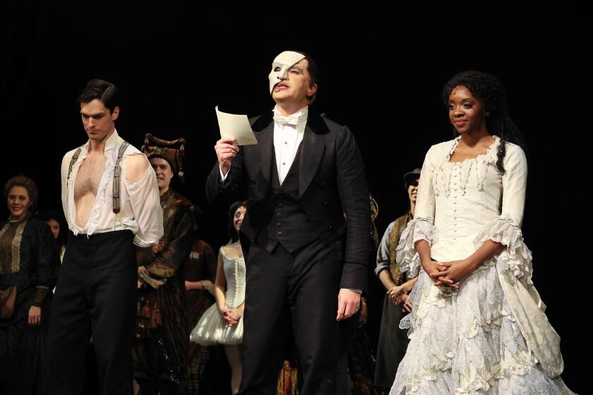 Cast members of "Phantom of the Opera" playing Raoul, The Phantom and Christine on stage after the curtain call 