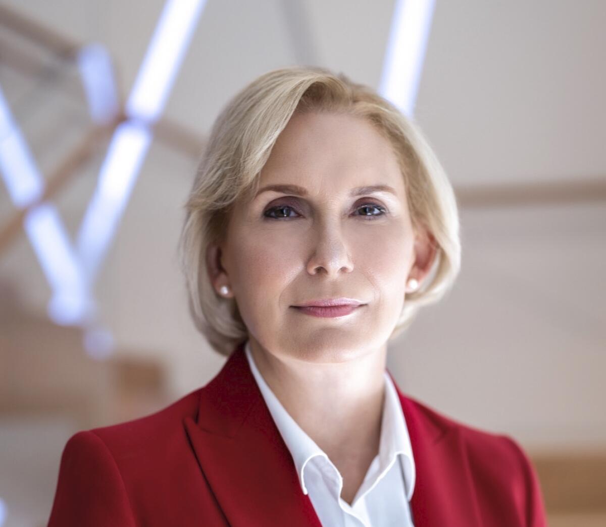 A blond woman wearing a red jacket